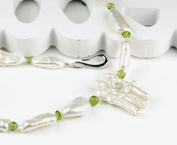 Einzigartige Kette aus länglichen, ungleichmäßigen Süßwasserzuchtperlen und Peridoten mit silber rhodiniertem S-Haken-Verschluss